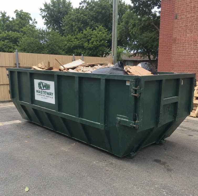 Construction debris dumpster filled with lumber and drywall