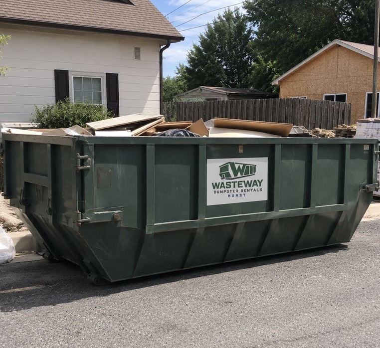 Wasteway green roll-off dumpster parked on a residential street